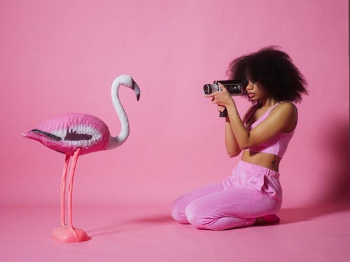 A Young Woman Video Recording A Plasprtic Flamingo Bird