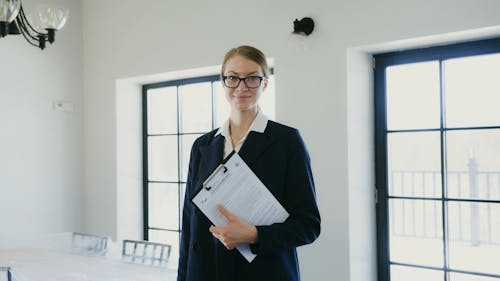 A Woman Wearing Corporate Attire Posing while Looking at Camera