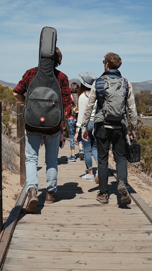 Back View of People Walking While Looking Around the Nature