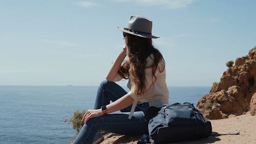 Woman Sitting on a Cliff