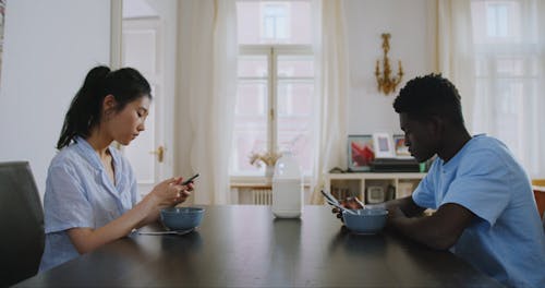 Man and Woman Focused On Using Their Smartphones