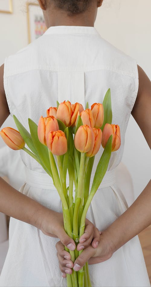 A Woman Holding Flowers Behind her Back