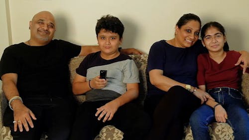 Family Sitting on the sofa while Watching