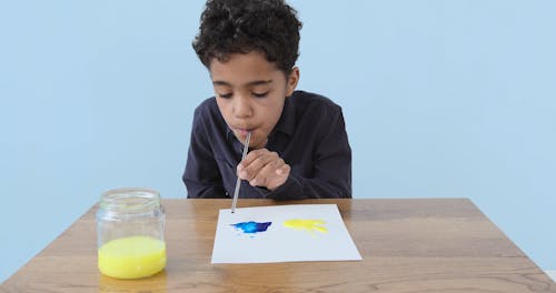 Boy Using Straw in Making Artwork