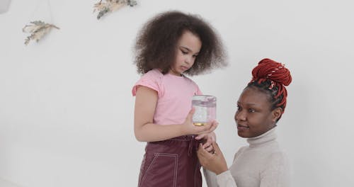 Girl Shaking a Jar Filled with Water