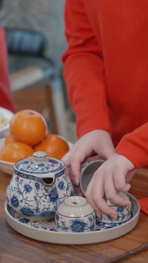 Person Pouring Tea in Cups