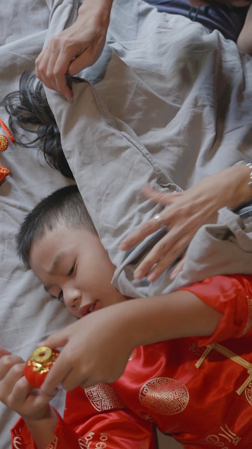 Children in Traditional Wear Lying on the Bed