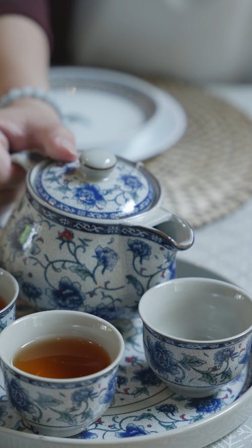 Close-Up Shot of Pouring Tea on a Teacup