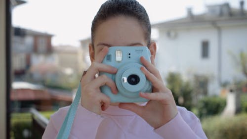 Woman Taking Photo Using an Instant Camera