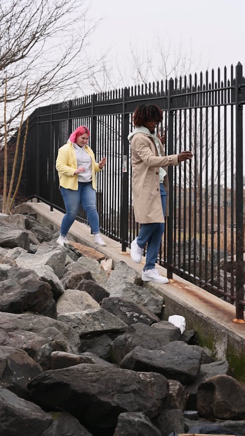 A Man and Woman Walking while Holding on Railings