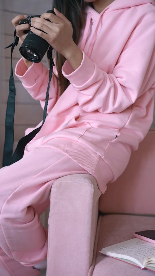 A Woman Holding Camera wearing Pink Hoodie