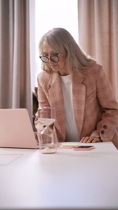 An Elderly Woman Typing on Her Laptop