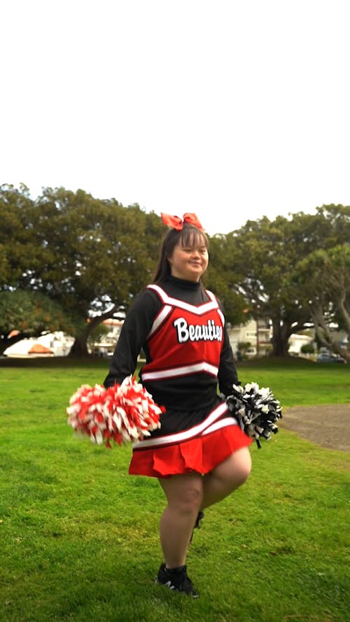 Girl with a Down Syndrome Hopping with a Cheerleading Costume at the Park