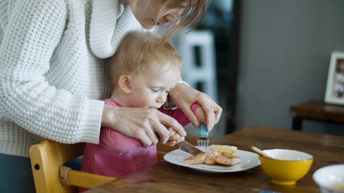 A Mother Helping Her Little Girl to Eat