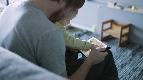 A Man Using His Tablet with His Child