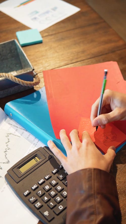 Person Writing on a Sticky Note