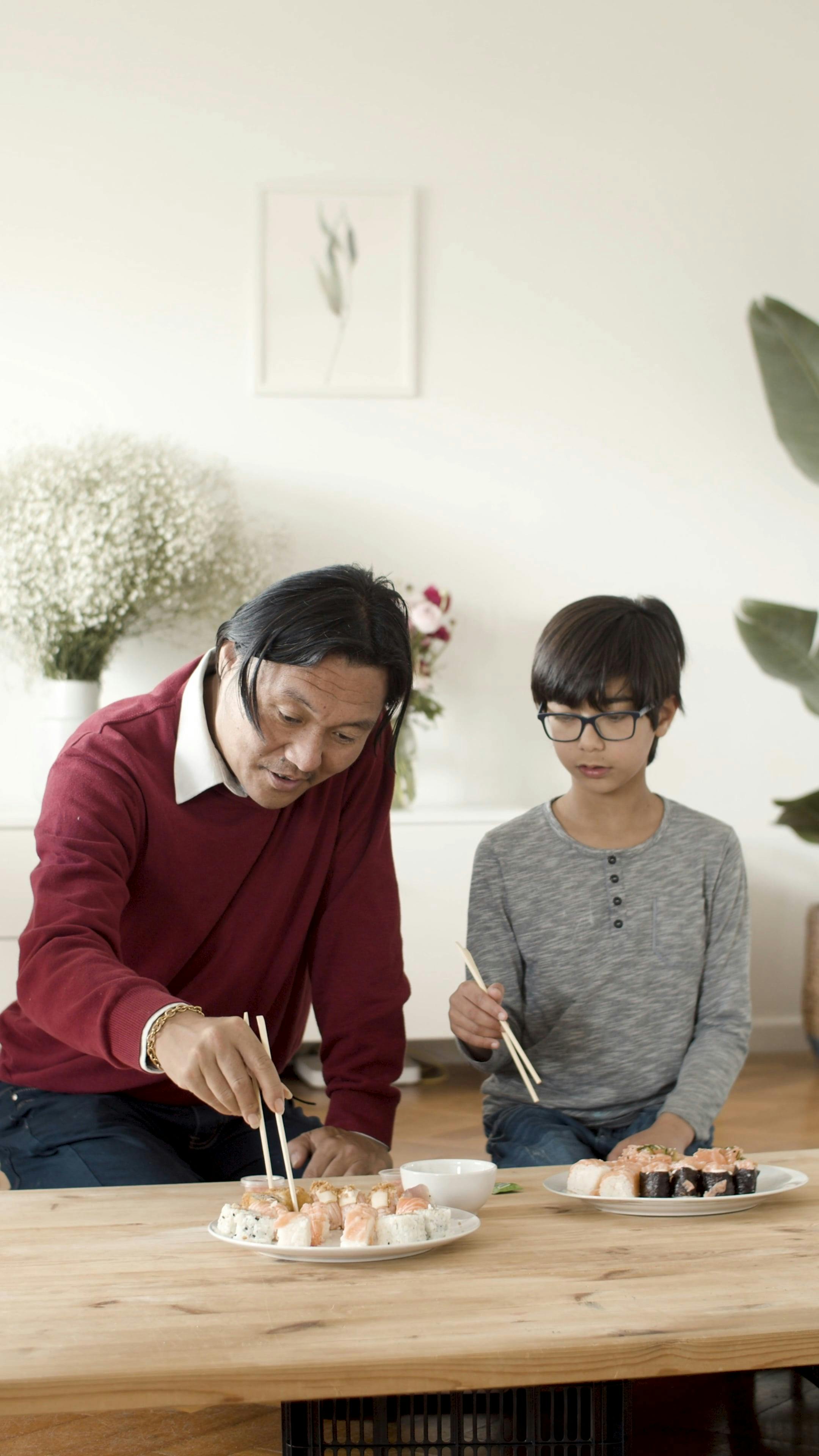 Man Teaching Boy How to Use Chopsticks · Free Stock Video
