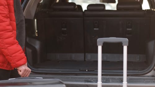 Man Putting His Suitcases on the Car