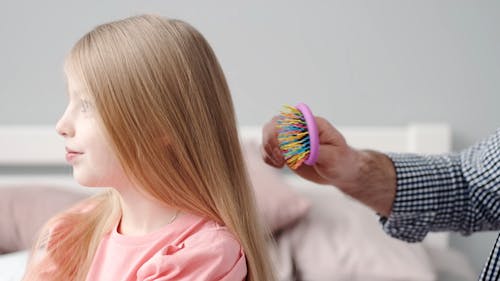 Man Brushing Girl Hair