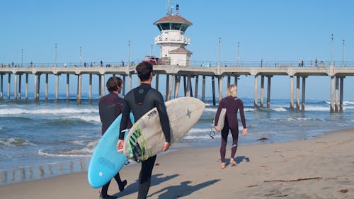 Surfers Walking In The Beach