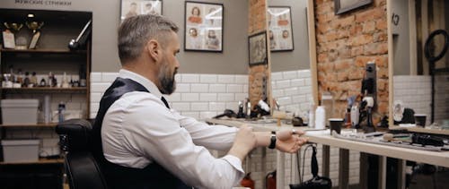 A Man Reading a Newspaper in a Barbershop