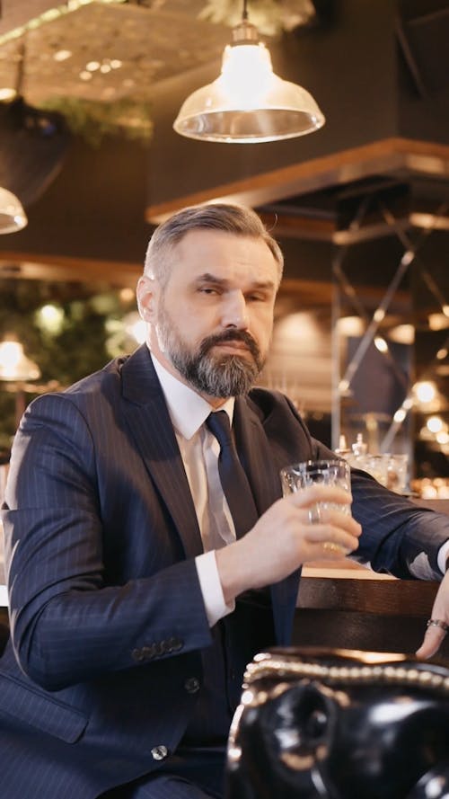 Businessman Drinking Whiskey at the Bar Counter of a Hotel Lounge
