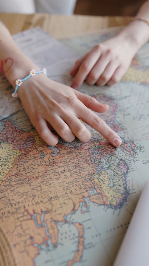 A Person Pointing on a World Map