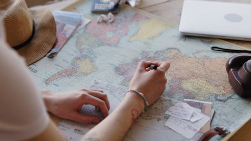 A Person Pointing on a World Map