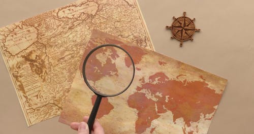 A Person Magnifying a World Map