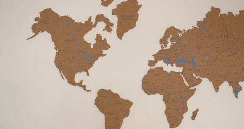 A Person Pointing Places in a World Map