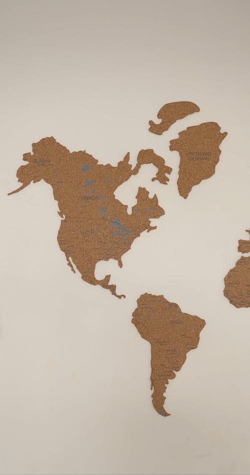 A Person Pointing Places in a World Map