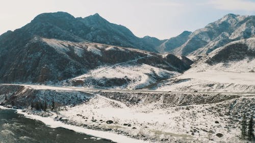 Cars on Frozen Road Near Mountains