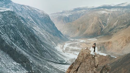 Woman Having a Phone Call while Sitting on a Peak