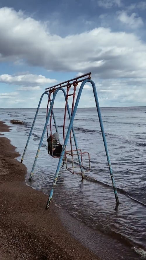 A Child on a Swing Set by the Seashore