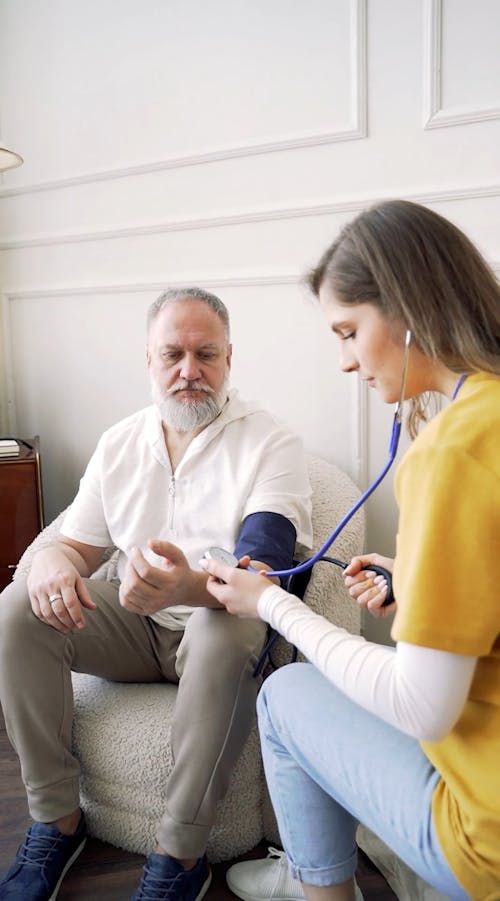 Woman Taking Blood Pressure of Elderly Man