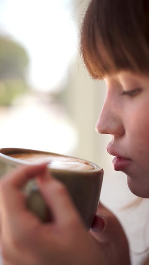Close-Up Video of an Attractive Woman Sipping Coffee 