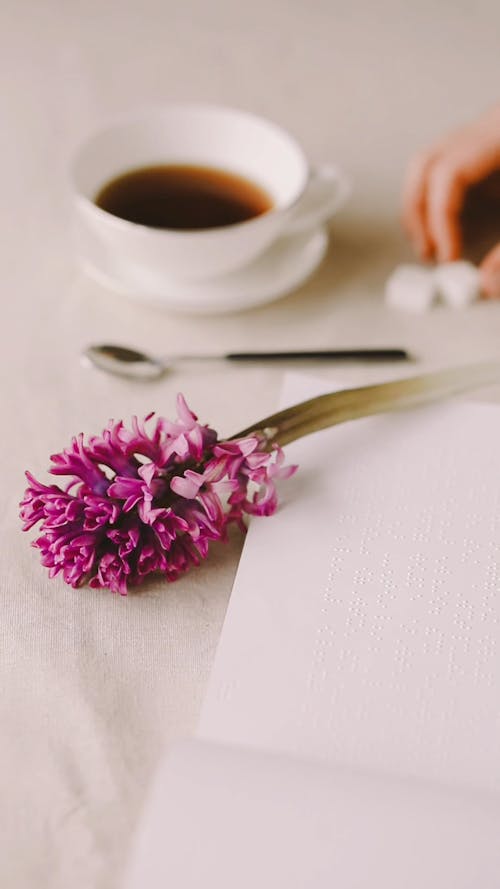 A Person Putting a Sugar Cube on a Hot Beverage