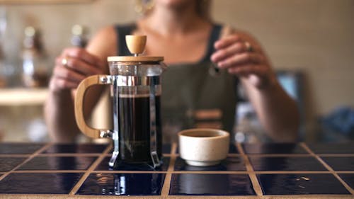 A Barista Serving a Brewed Coffee