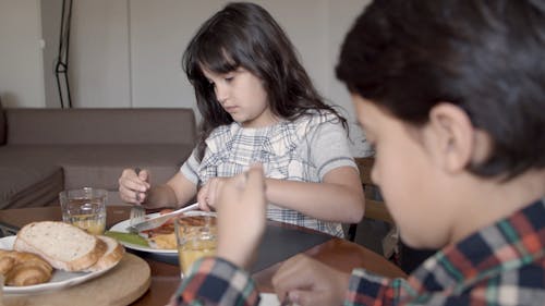 Girl Slicing Food with a Table Knife