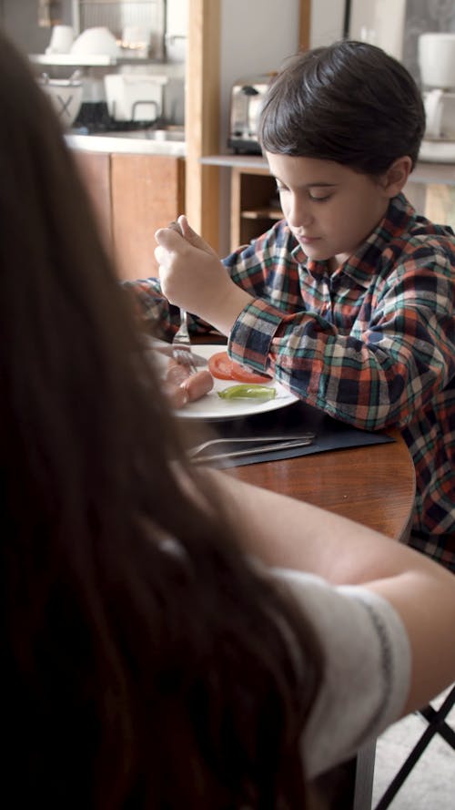 Child Slicing a Sausage