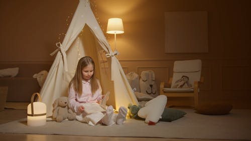 A Girl Reading a Book while on the Floor