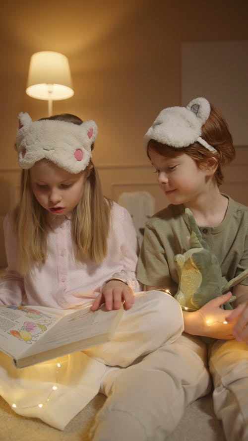 A Girl and a Boy Reading a Book Together