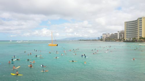 Drone Footage of People Surfboarding in the Beach