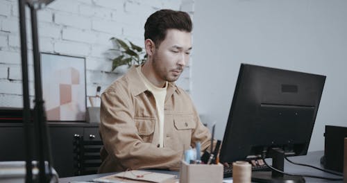 A Man Sketching on a Notebook