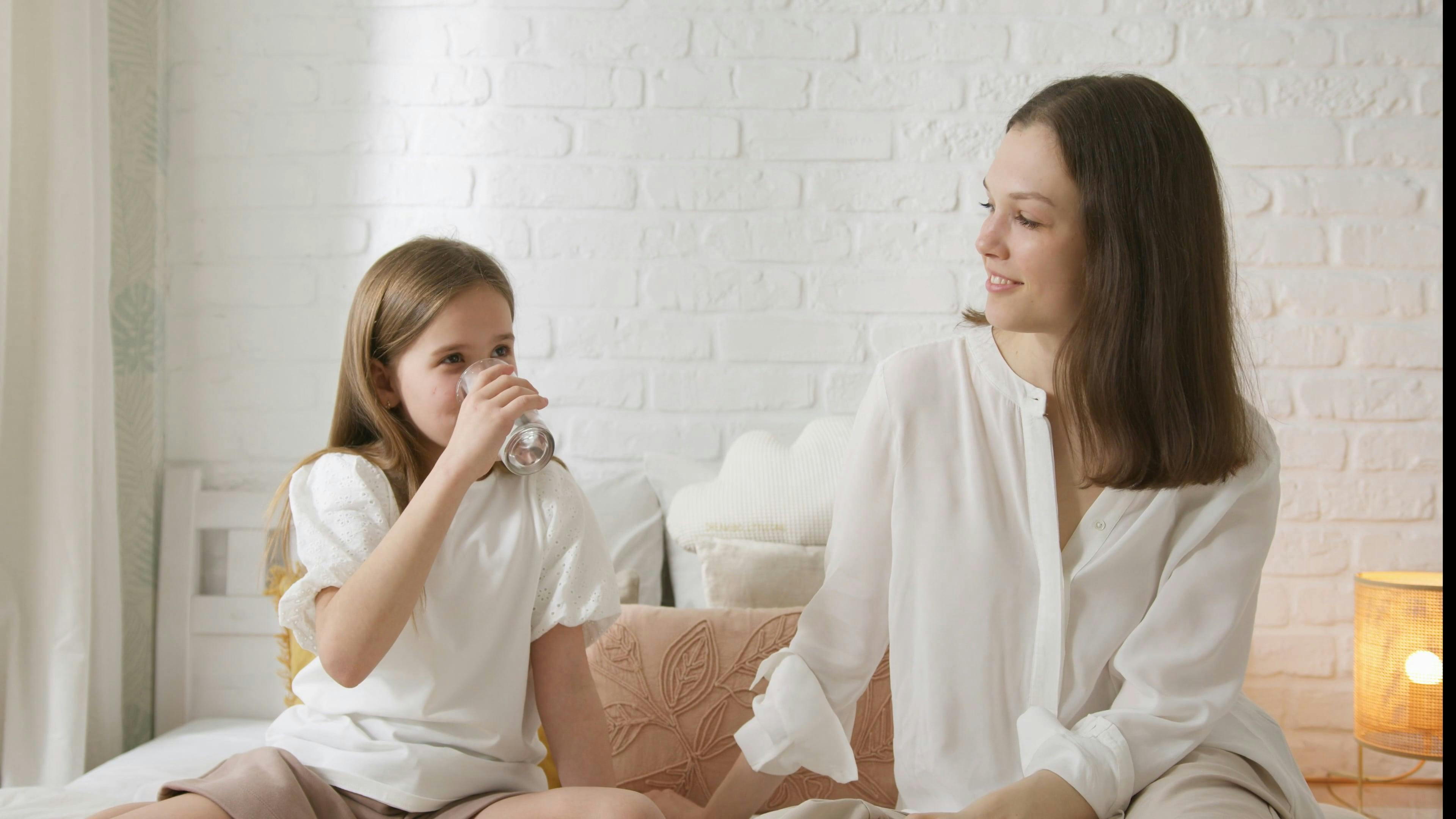 Girl Sitting on Bed Drinking Water · Free Stock Video