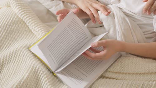 Mother and Daughter Reading Book in Bed