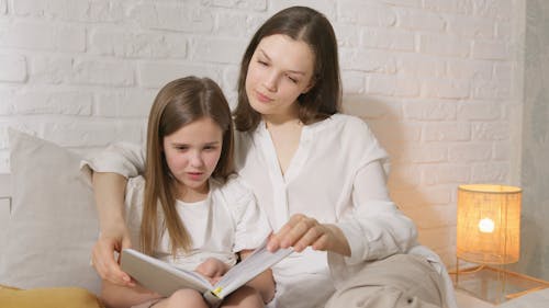 A Woman Reading a Book with her Daughter