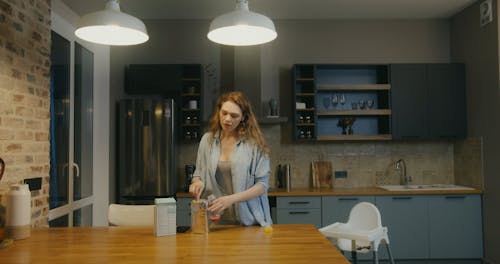 Woman Singing and Dancing while Preparing a Baby Bottle