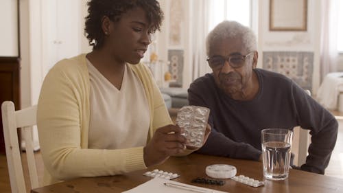 A Woman Instructing the Elderly Man to the Medicine 