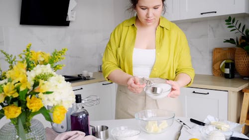 A Woman Putting Sugar into the Bowl